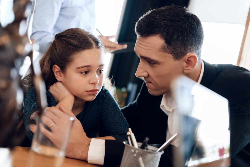 A father calms his young daughter.