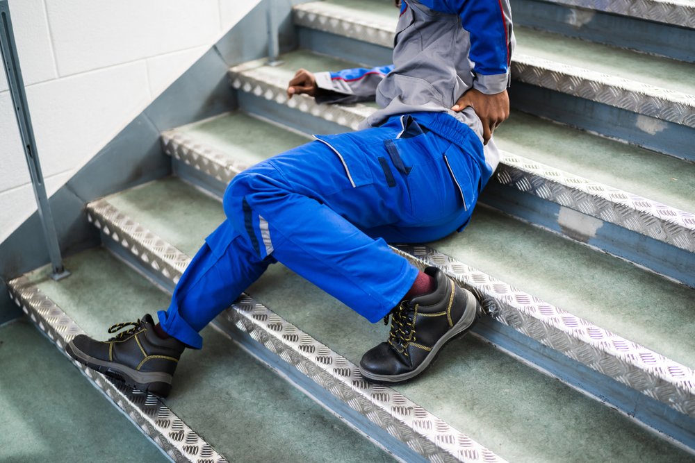 An injured worker on stairs.