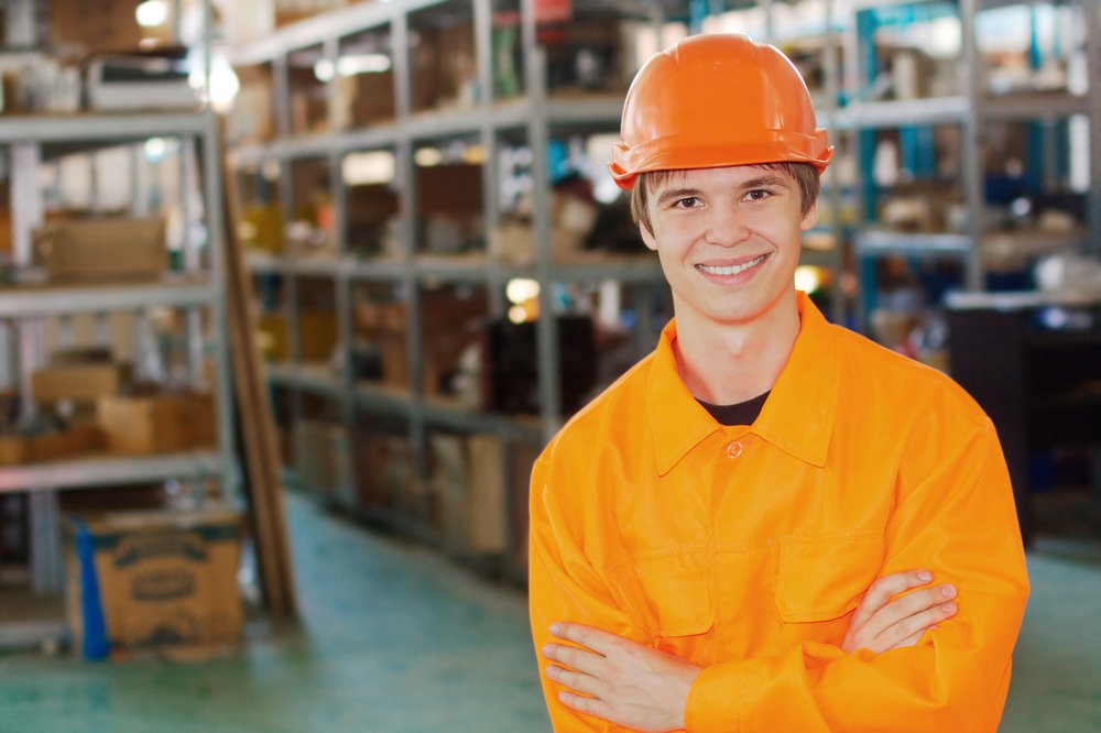A smiling teen wearing hi-visibility workwear.