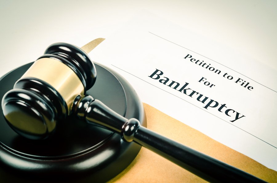 Gavel next to a paper that says "petition to file for bankruptcy"