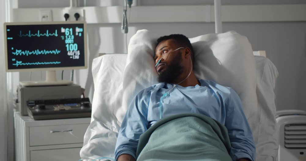 A seriously injured man lying in a hospital bed.