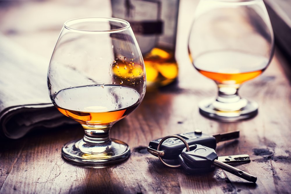 Car keys laid out next to two alcoholic beverages.