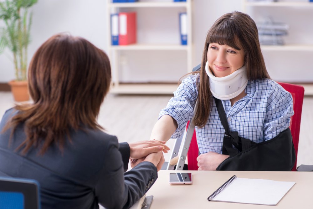 A woman relieved to finally settle her personal injury case, shaking hands with her lawyer.