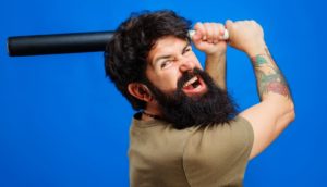 A man swinging a bat at someone, as an example of assault with a deadly weapon.