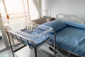 Hospital bed and baby bed in hospital room 