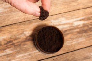 A person picking up some chewing tobacco out of a can.