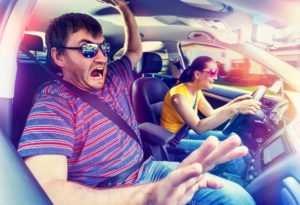 A woman driving fast while her passenger screams in fear from her gross negligence.