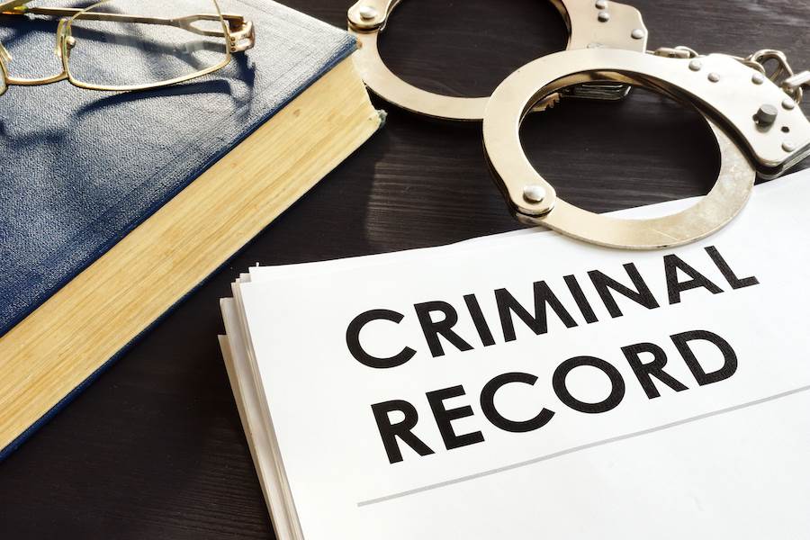 Paper that says "criminal record" with handcuffs
