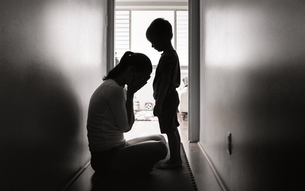 A grieving mother and her boy, traumatized in their hallway.