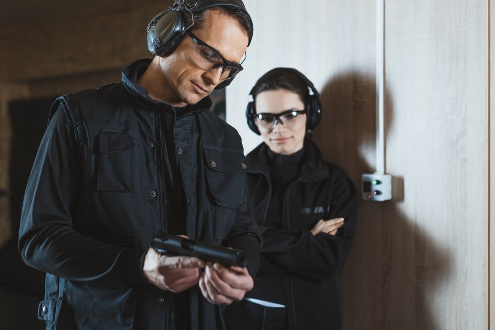 Dos personas practicando prácticas de seguridad de armas en el campo de tiro.