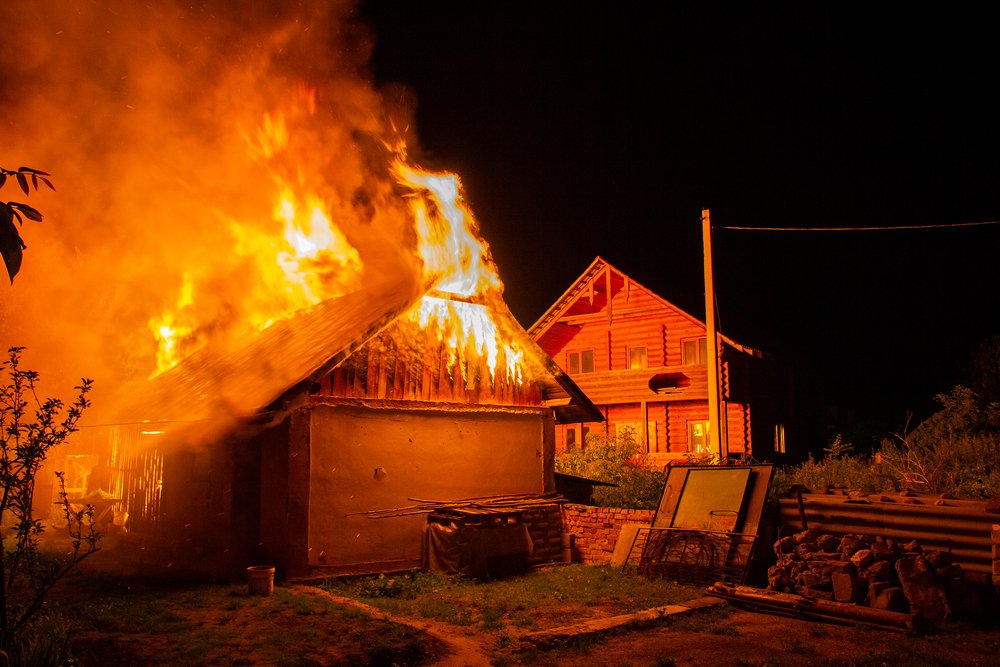 A house on fire, potentially as a result of arson.