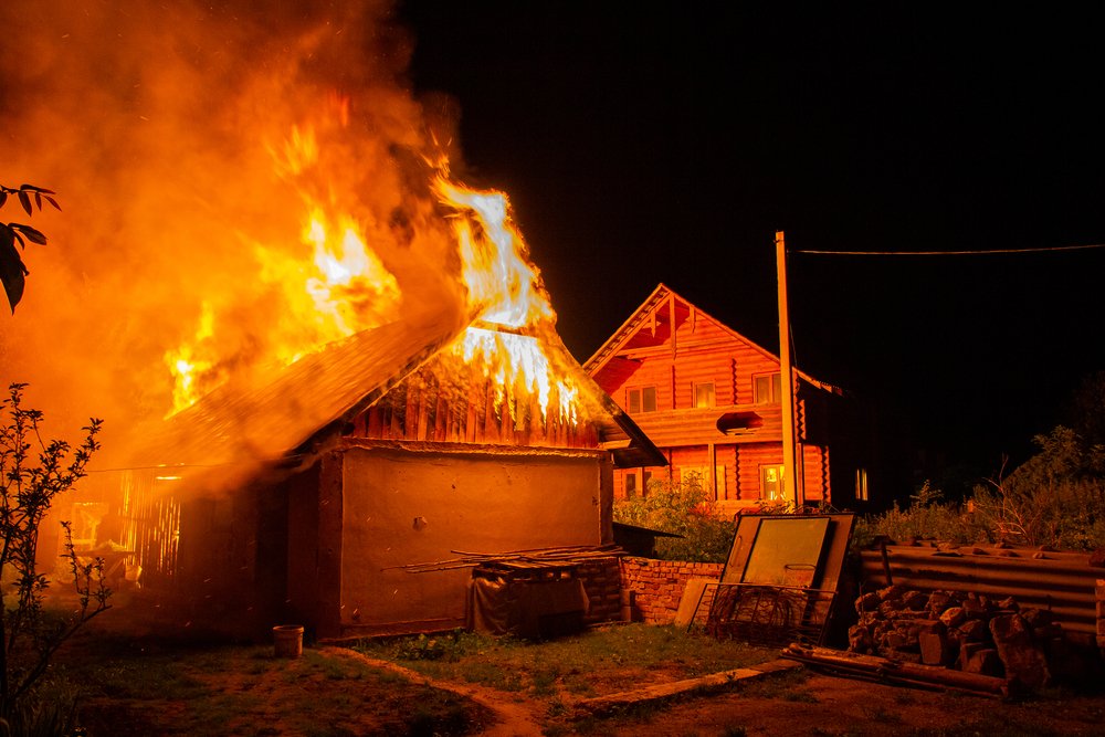 A house on fire, potentially as a result of arson.