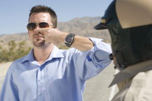 A man performing a finger-to-nose field sobriety test.