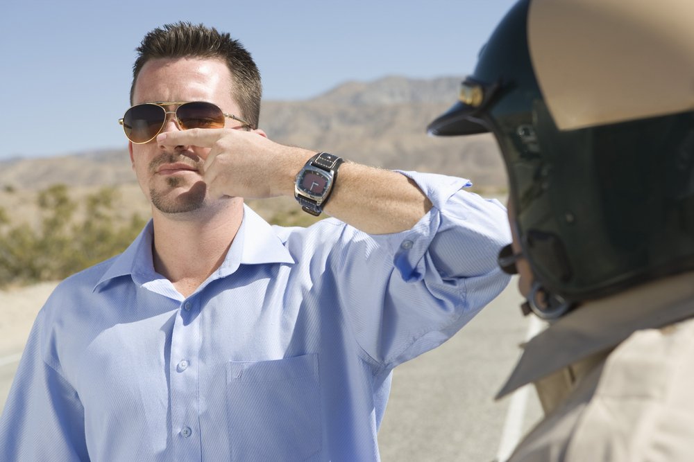 A man performing a finger-to-nose field sobriety test.