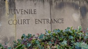 Weathered stone slab sign with the words juvenile Court Entrance