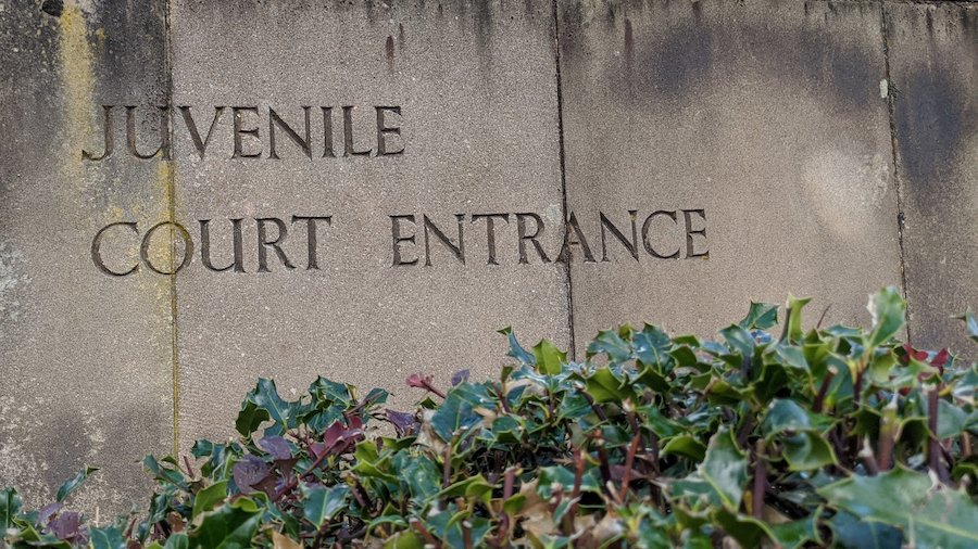 Weathered stone slab sign with the words juvenile Court Entrance