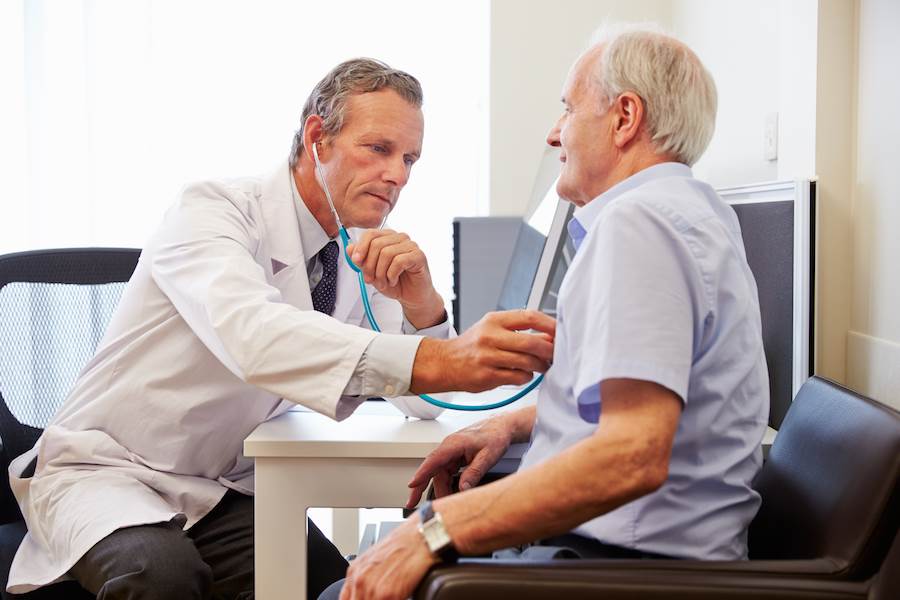 Doctor examining patient's heart