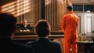 Man in orange jumpsuit in front of judge