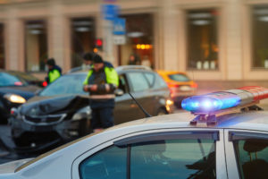 Police investigating a hit and run scene on a city street at night.