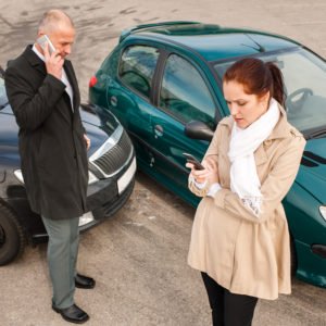 Dos conductores intercambiando información después de un accidente de auto