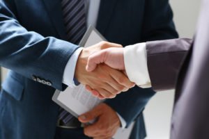 Dos abogados estrechando manos después de un acuerdo