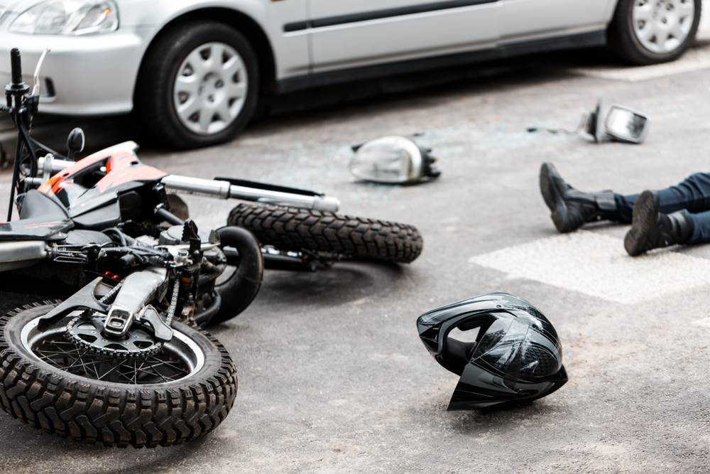 An injured motorcyclist on the ground after a motorcycle accident.