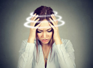 A woman experiencing the effects of post concussion syndrome, such as dizziness and vertigo.