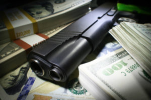 Arma de fuego y varios fajos de dinero