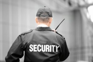 A security guard talking into his walkie talkie.