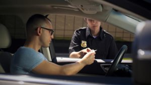 Mujer policía revisando documentos de conductor masculino