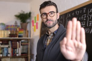 Teacher holding hand up to deflect an assault