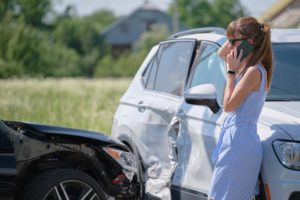 A young woman on the phone with her insurance provider after her leased car was totaled after a crash.