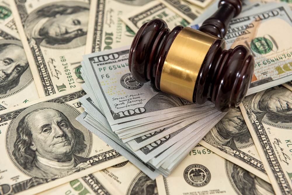 Money under a gavel from a wrongful death lawsuit settlement.