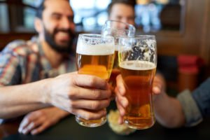 A group of people enjoying their time together over some beer.