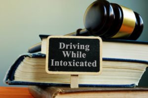gavel and books with small sign that says "driving while intoxicated"