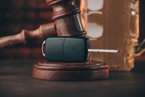 Gavel on top of a card key in front of a mug of beer