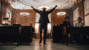 A man celebrating as he exits a courtroom, possibly for avoiding a misdemeanor.