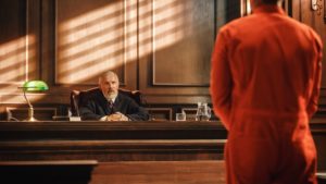 Man in orange jumpsuit in front of judge