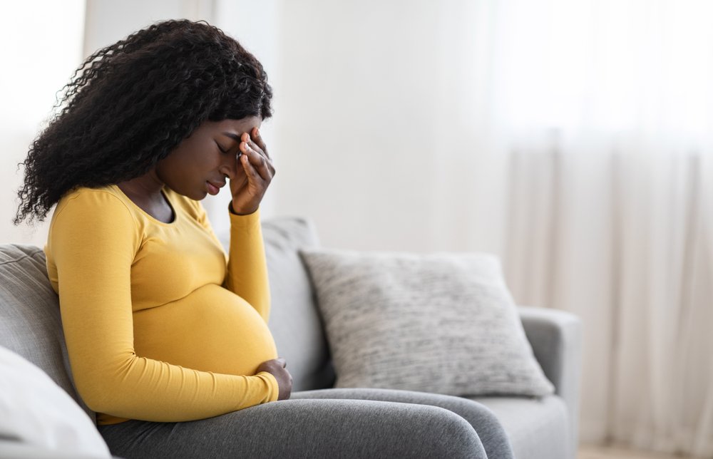 A woman grieving due to the undeserved discrimination she has been receiving due to being pregnant.