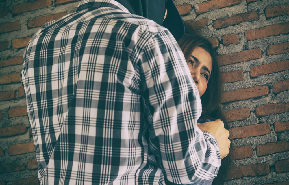 A woman being sexually assaulted by a masked man. Since she is not a minor, it is considered sexual assault and not sexual abuse (in most states).