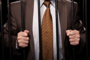 Man in suit behind bars