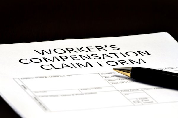 Workers' comp claim form with a pen