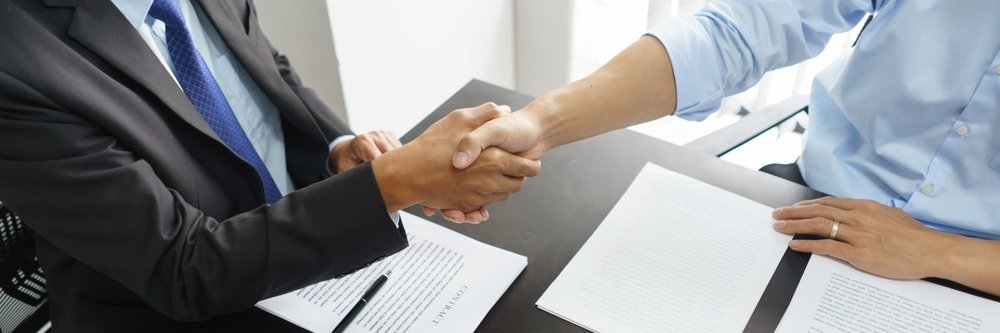 An attorney and his client shaking hands in agreement.