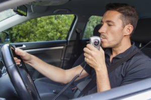 Driver blowing into ignition interlock device
