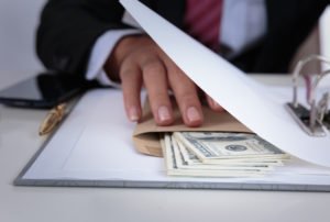 Hombre de negocios escondiendo una bola de dinero