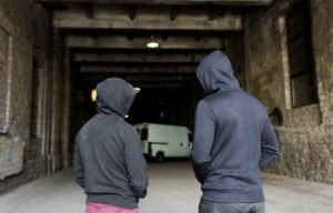 Two hooded gang members in an alley