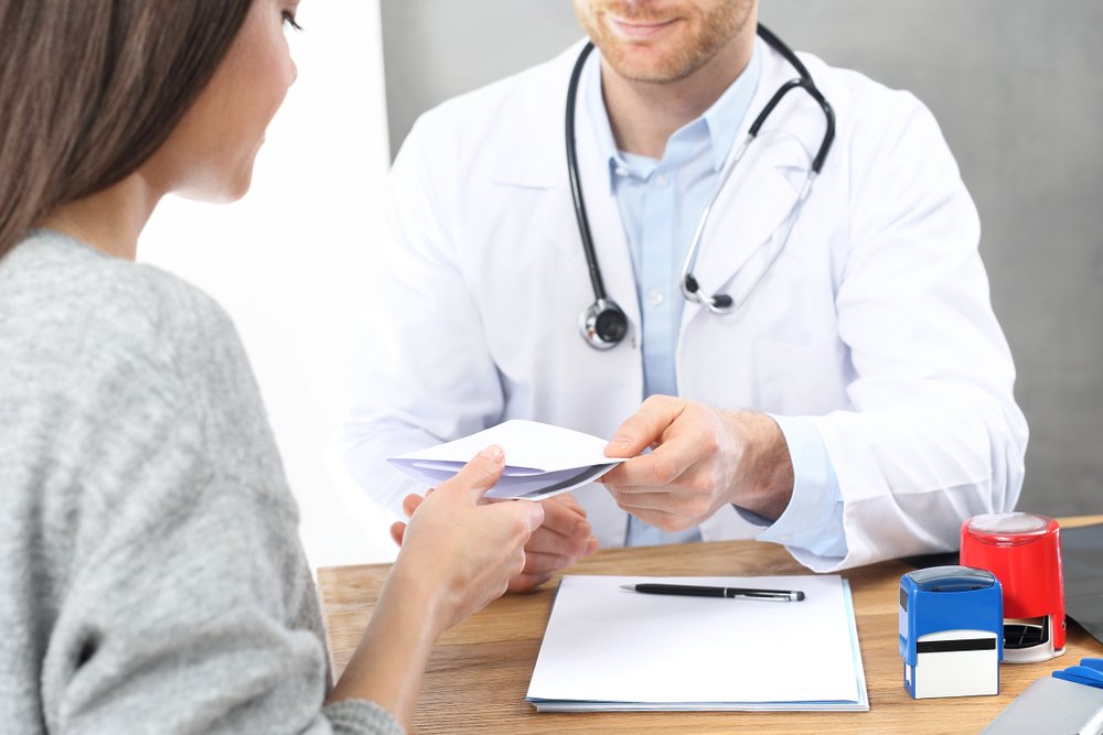 A patient receiving a prescription note from a physician, whom she might have found my "doctor shopping."