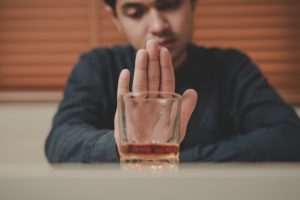 Man pushing away a tumbler of alcohol