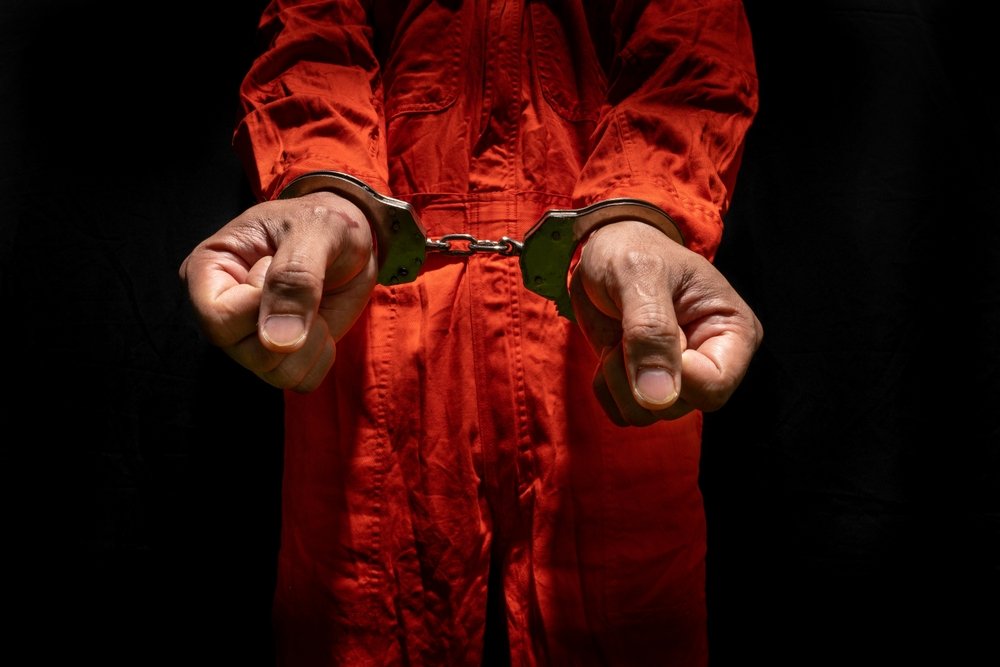 A prisoner wearing an orange jumpsuit due to being convicted of meth lab charges.