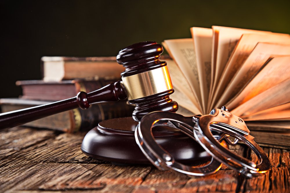 Legal books next to a gavel and handcuffs, representing the legal concepts of probation and parole.